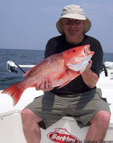 Kip holds up a harty 26 inch red snapper he caugth 5 miles off of pensacola .
