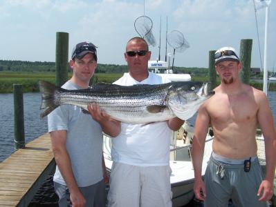Jason Johnson is shown holding his 33-pound striped bass with buddies P ete Menges and Jerry Barlow.